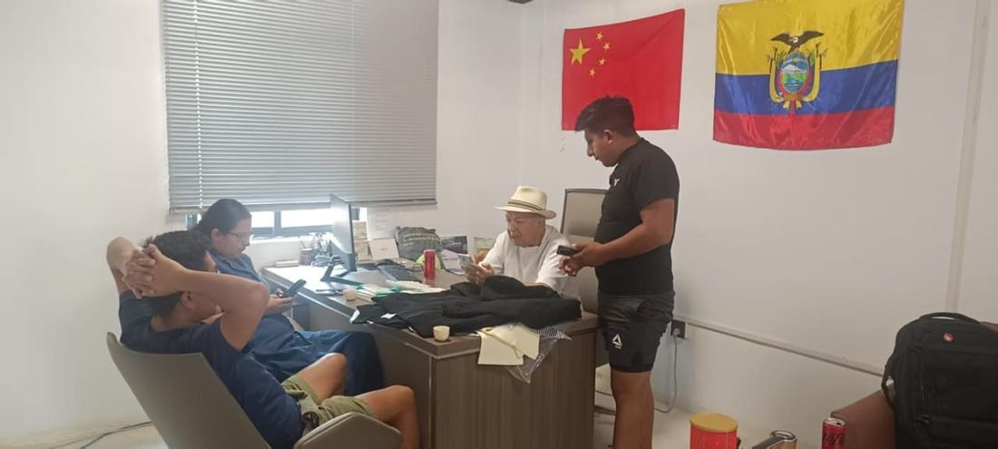 Sala de trabajo con banderas de China y Ecuador durante una jornada de negociación