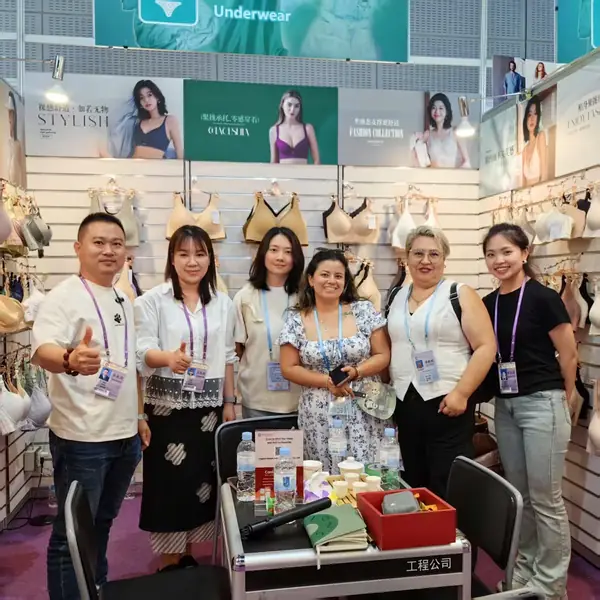 Grupo de empresarias de China Business Group junto a los expositores de un stand textil