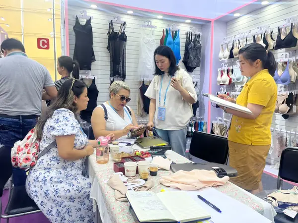 Revisión de muestras de lencería y catálogos en la feria