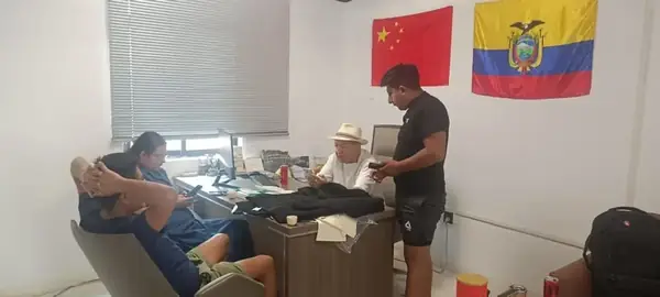 Sala de trabajo con banderas de China y Ecuador durante una jornada de negociación
