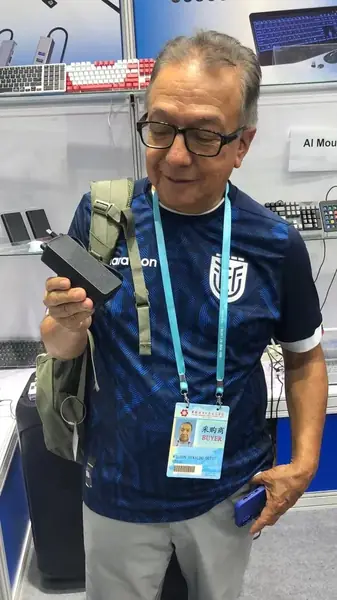 Asesor revisando un dispositivo electrónico en un stand de la feria