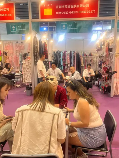 Clientas atendidas en el stand de una empresa de confección china