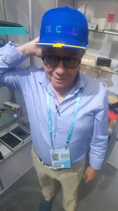 Asesor probando una gorra con pantalla LED en la feria